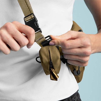 Person adjusting a brown waist bag with a white background